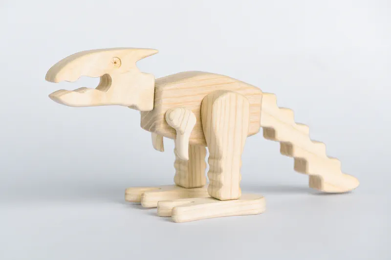 Mali dinosaurus Dino od punog drveta, pogled sa strane
